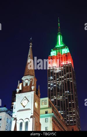 NEW YORK CITY, NY - DEC 30: Empire State Building and church on December 30, 2011 in New York City. It is a 102-story landmark and was world`s tallest building for more than 40 years. Stock Photo
